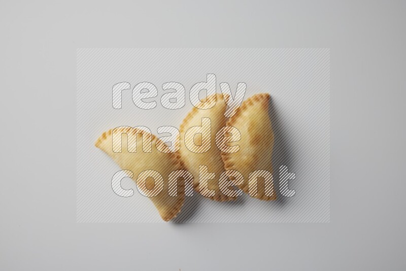 Three fried sambosa from a top angle on a white background