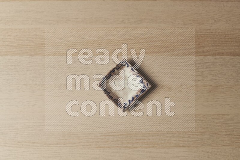 A decorative pottery plate on light wooden background