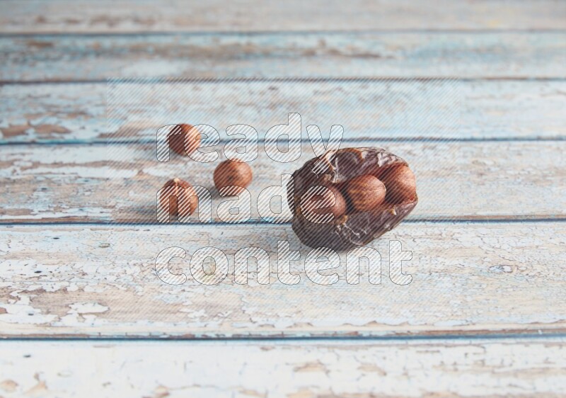 hazelnuts stuffed madjoul date on a light blue wooden background