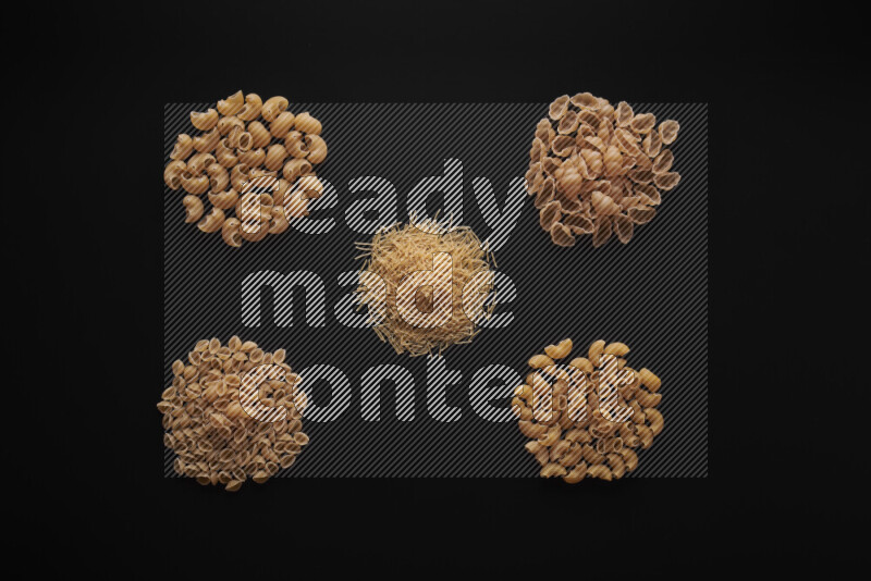 Different pasta types in bunches on black background