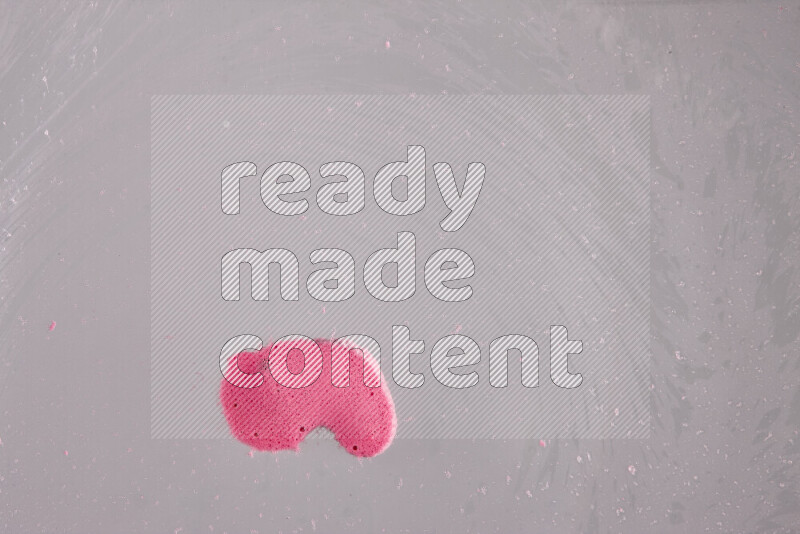 The image captures a dramatic splatter of pink paint over a white backdrop