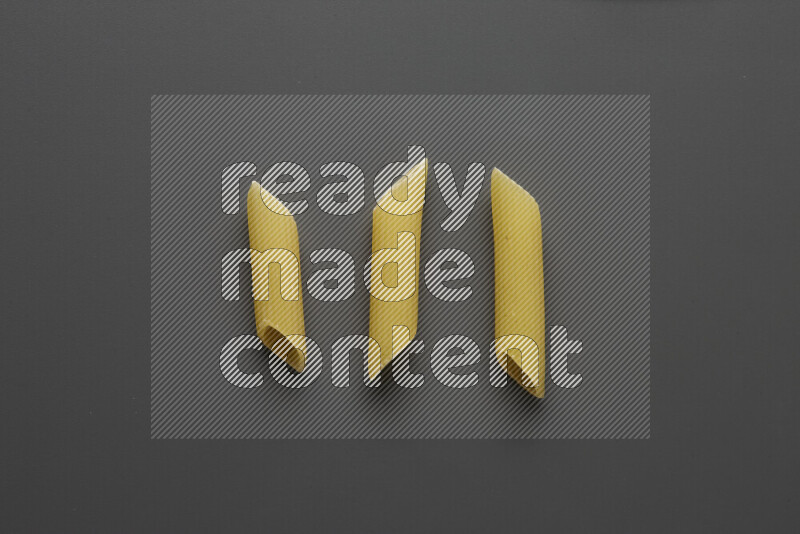 Penne pasta on grey background