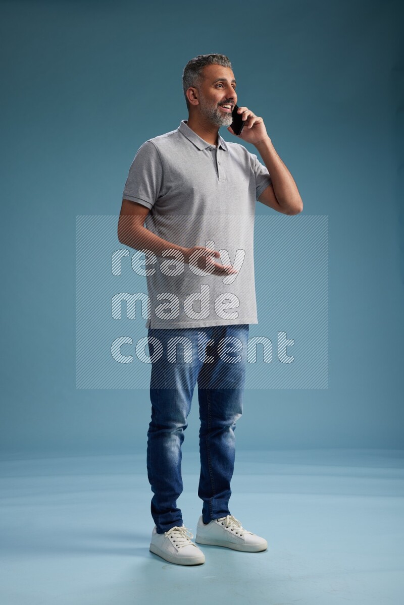 Man Standing talking on phone on blue background