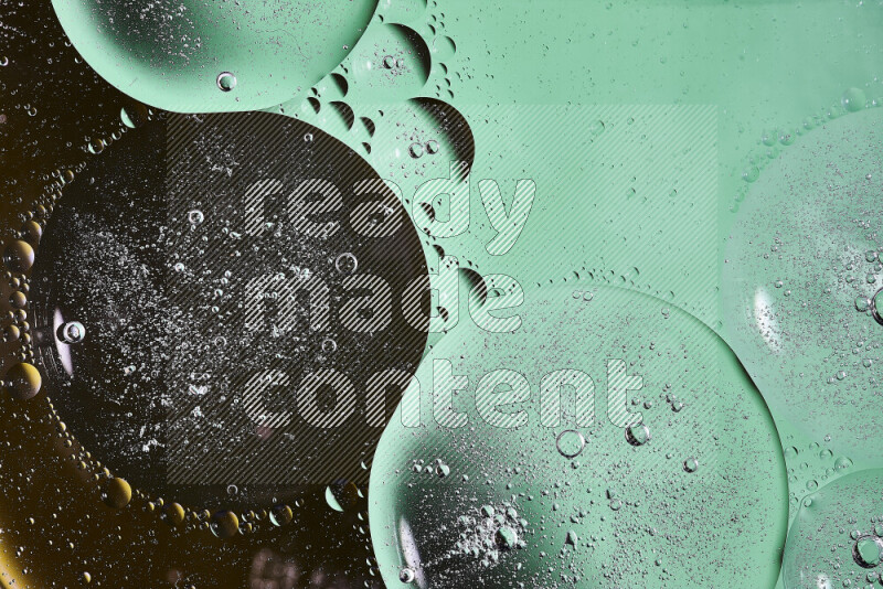 Close-ups of abstract oil bubbles on water surface in shades of black and green