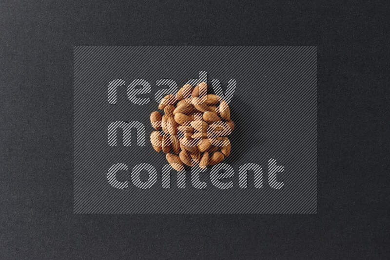 A bunch of peeled almonds on a black background in different angles
