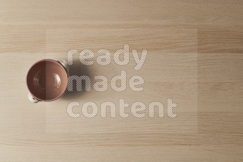 A multicolored pottery pot on light wooden background