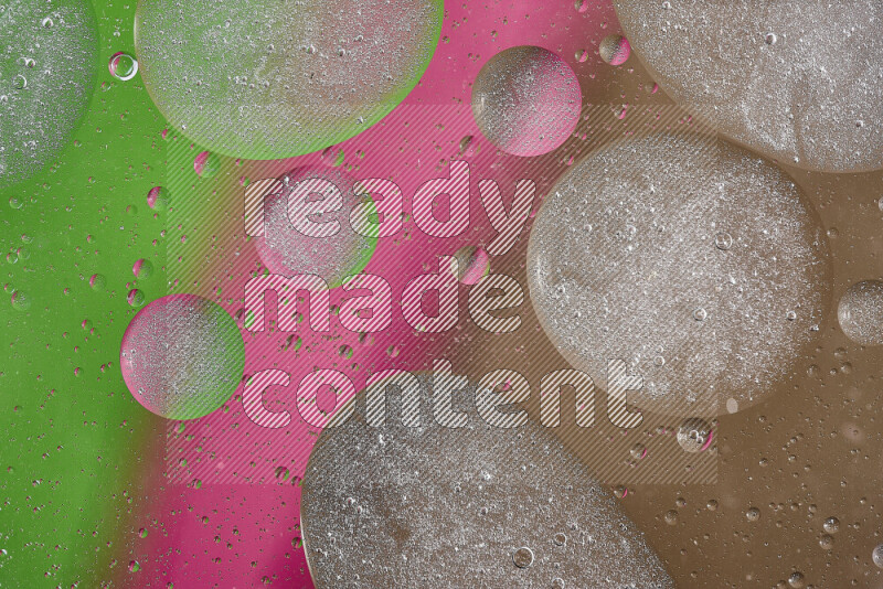 Close-ups of abstract oil bubbles on water surface in shades of brown, green and pink