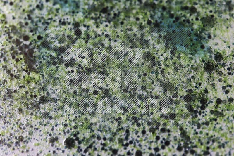 Close-ups of abstract green and blue watercolor drops on oil Surface on white background