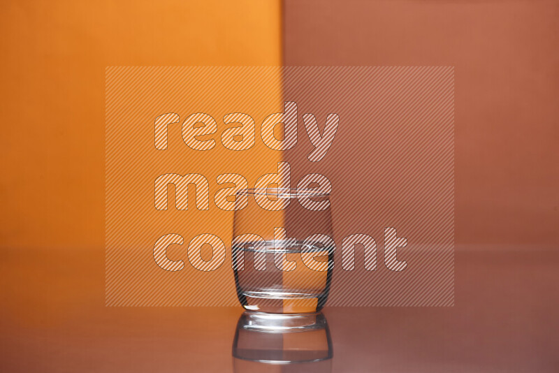 The image features a clear glassware filled with water, set against orange and dark orange background