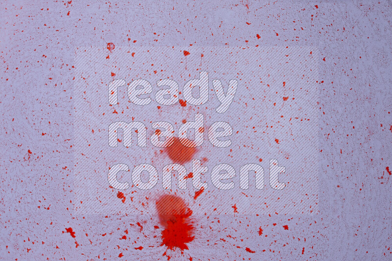 The image captures a dramatic splatter of red paint over a white backdrop