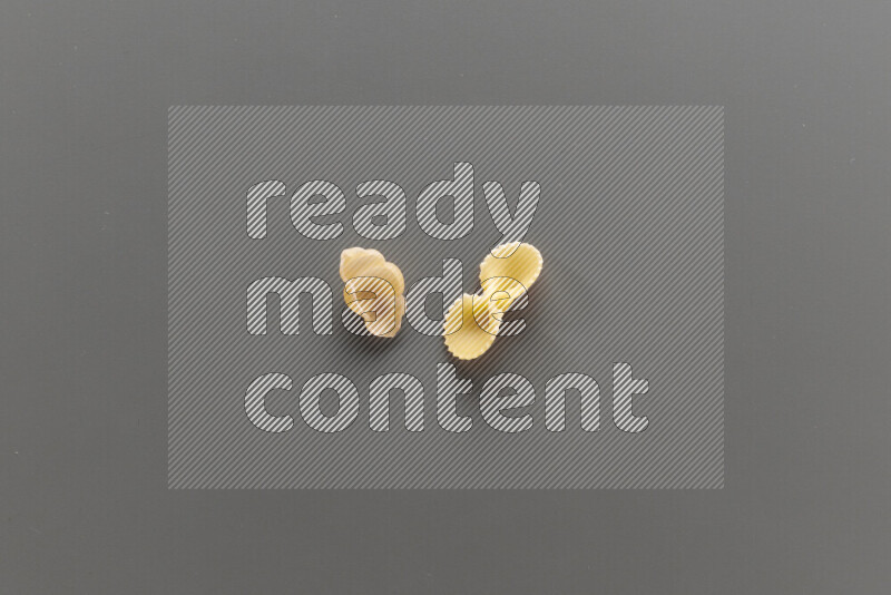 Snails pasta with other types of pasta on grey background