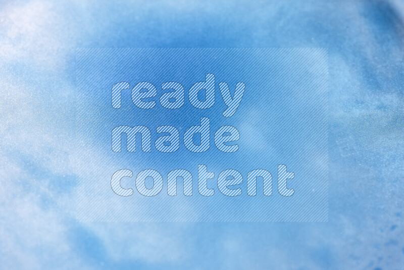 لقطات مقربة لقطرات ألوان مائية زرقاء على سطح الزيت على خلفية بيضاء