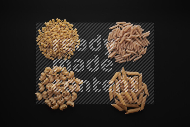 Different pasta types in bunches on black background