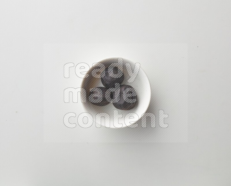 Top-view shot of dried lime (loomi) in a container on white background