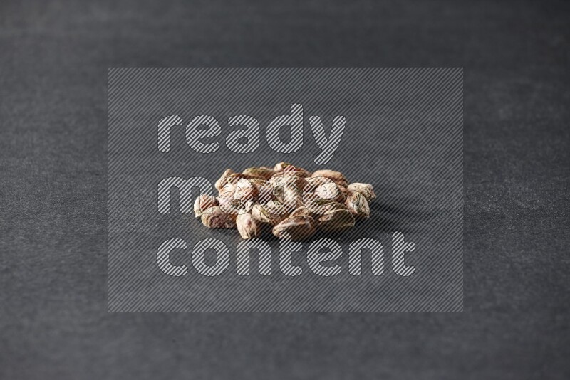 A bunch of peeled pistachios on a black background in different angles