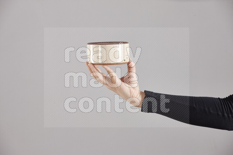 A woman in black abaya holding different pottery essentials in different positions