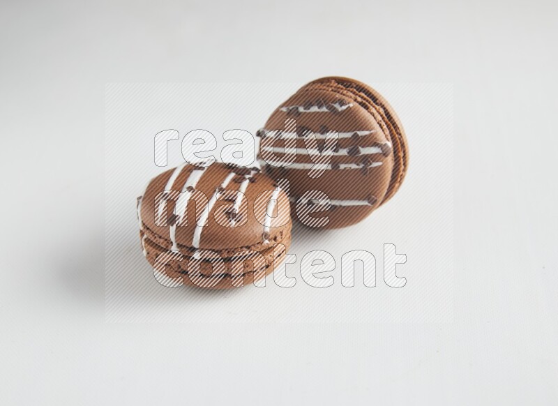 45º Shot of two Brown white Chocolate Caramel macarons on white background