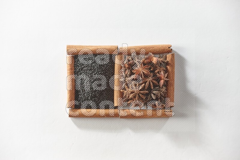 2 squares of cinnamon sticks full of black seeds and star anise on white flooring
