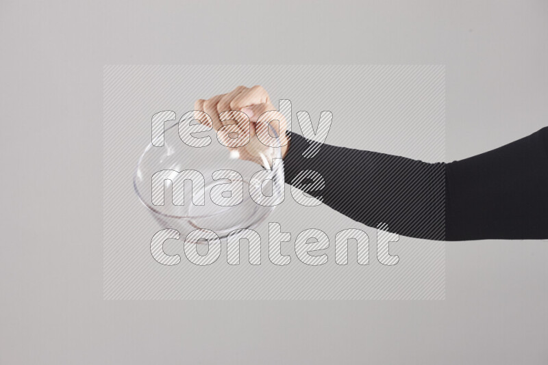 امرأة ترتدي عباءة سوداء تحمل أدوات زجاجية مختلفة في أوضاع متعددة