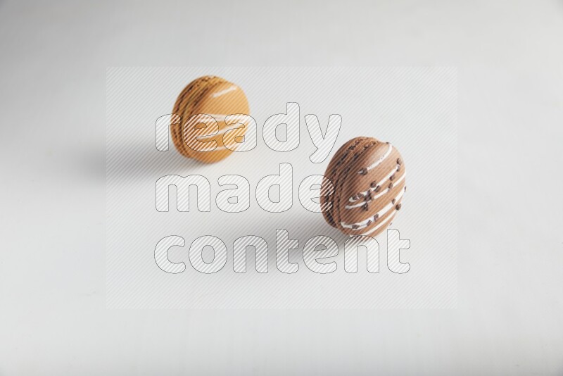 45º Shot of of two assorted Brown Irish Cream, and Brown white Chocolate Caramel macarons on white background