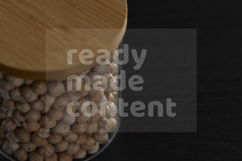 Chickpeas in a glass jar on black background
