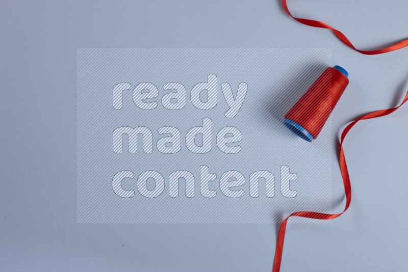 A red collection of sewing and tailoring tools arranged on a blue background