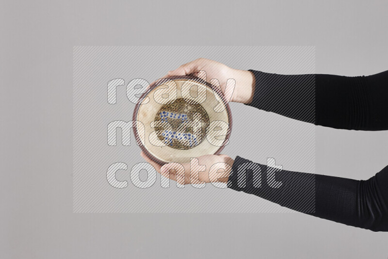 A woman in black abaya holding different pottery essentials in different positions