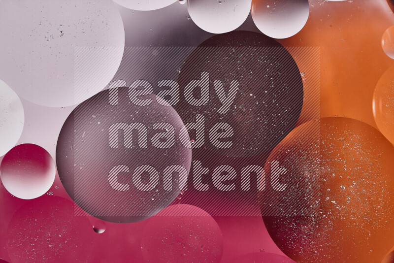 Close-ups of abstract oil bubbles on water surface in shades of white, orange and pink