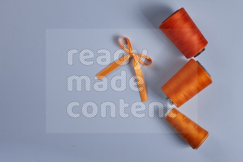 An orange collection of sewing and tailoring tools arranged on a blue background