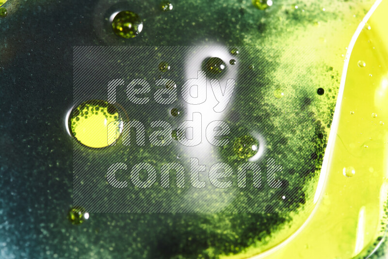 Close-ups of abstract green and yellow watercolor drops on oil Surface on white background