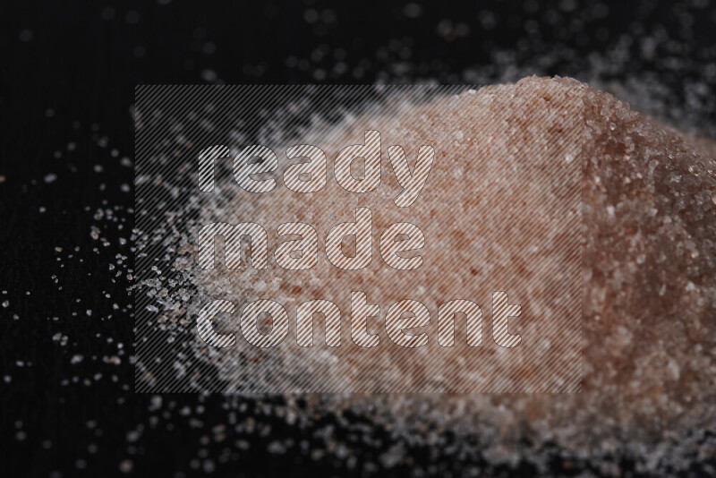 حفنة من ملح الهيمالايا الناعم على خلفية سوداء