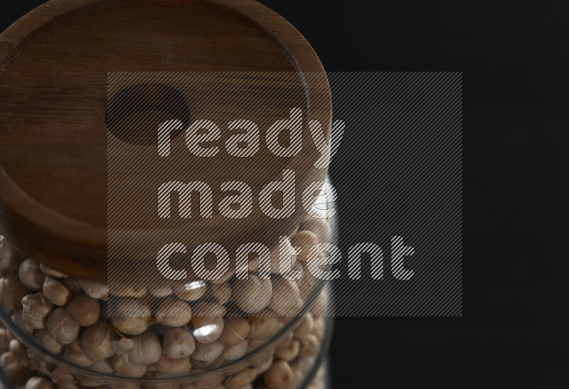Chickpeas in a glass jar on black background