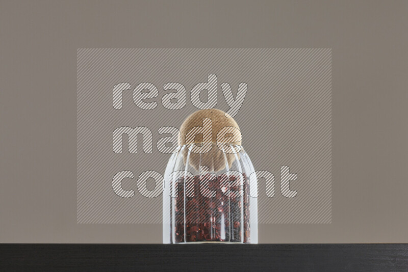 Sequins in a glass jar on black background