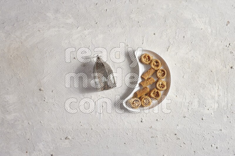 حلويات شرقية في صحن فخاري مع فانوس معدني