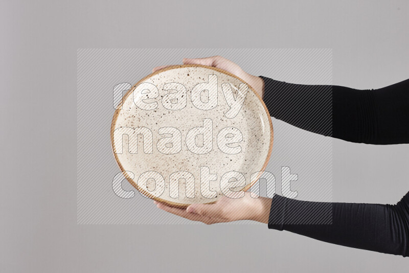 A woman in black abaya holding different pottery essentials in different positions