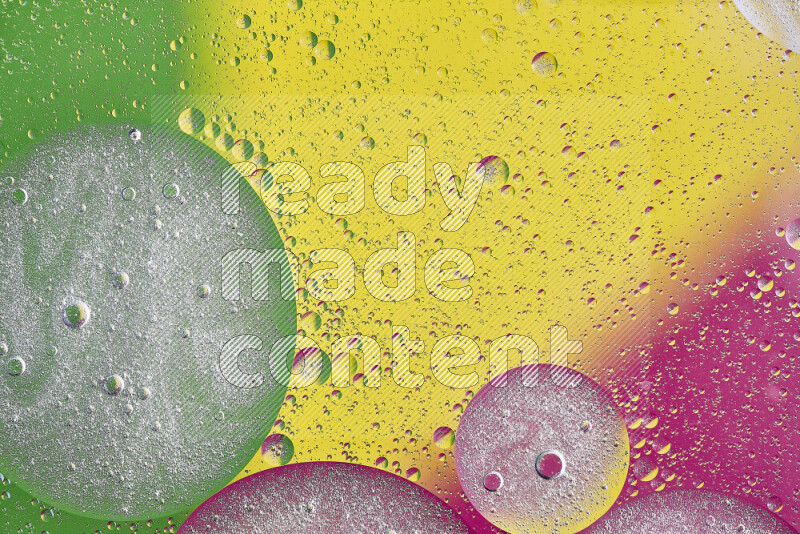 Close-ups of abstract oil bubbles on water surface in shades of yellow, green and pink