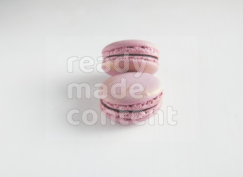 45º Shot of two Purple Strawberry macarons on white background