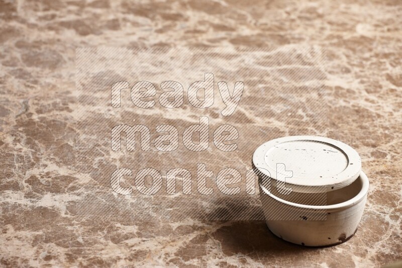 A white pottery bowl on beige marble background