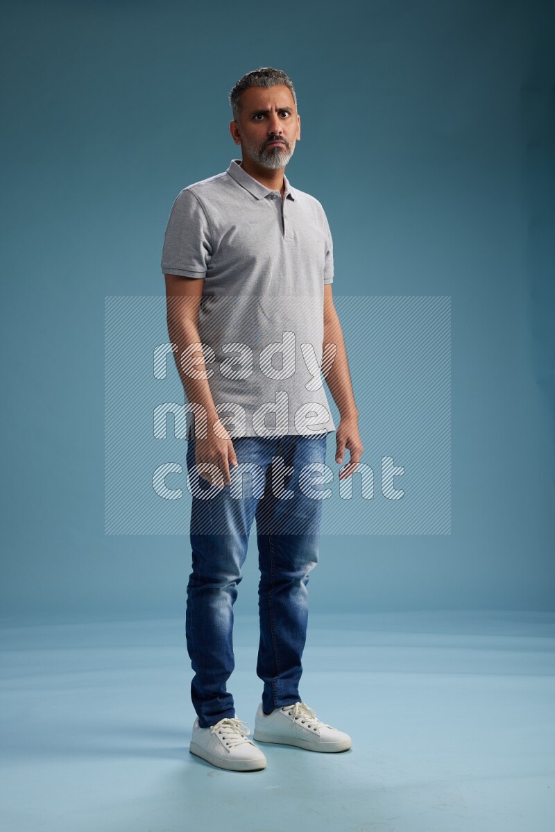 Man Standing Interacting with the camera on blue background