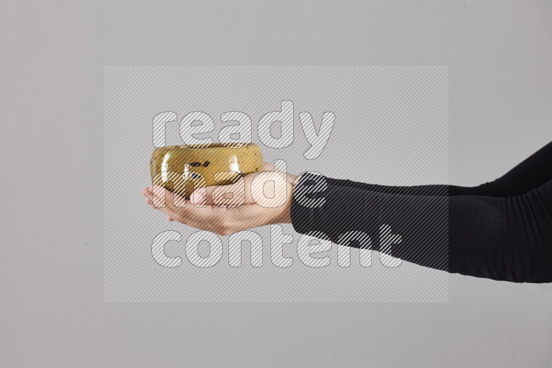 امرأة ترتدي عباءة سوداء تحمل أدوات فخارية مختلفة في أوضاع متعددة