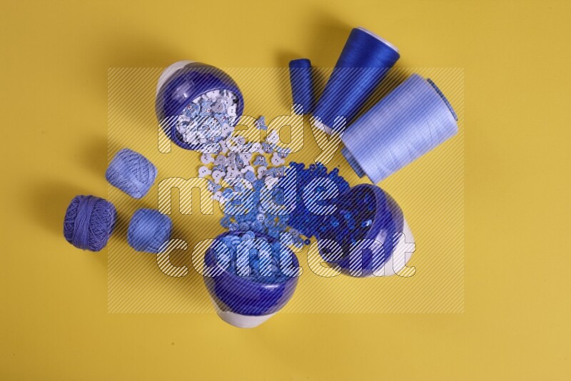 A blue collection of sewing and tailoring tools arranged on a yellow background