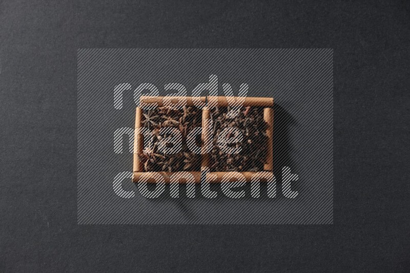 2 squares of cinnamon sticks full of star anise and cloves on black flooring