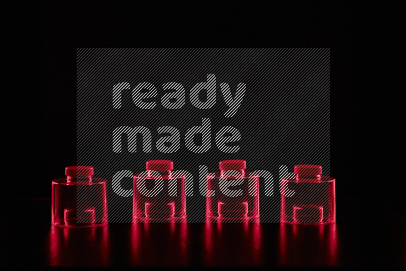 أواني زجاجية مع حواف مضيئة باللون الأحمر على خلفية سوداء