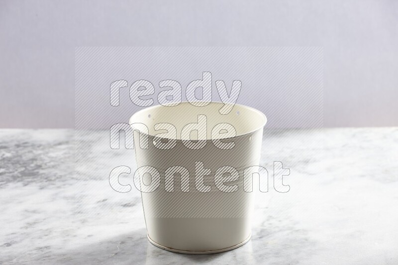 An empty white plant pot on grey marble background