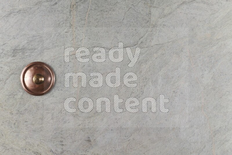 A small copper pot on grey marble background