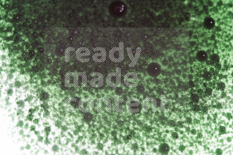 Close-ups of abstract green watercolor drops on oil Surface on white background