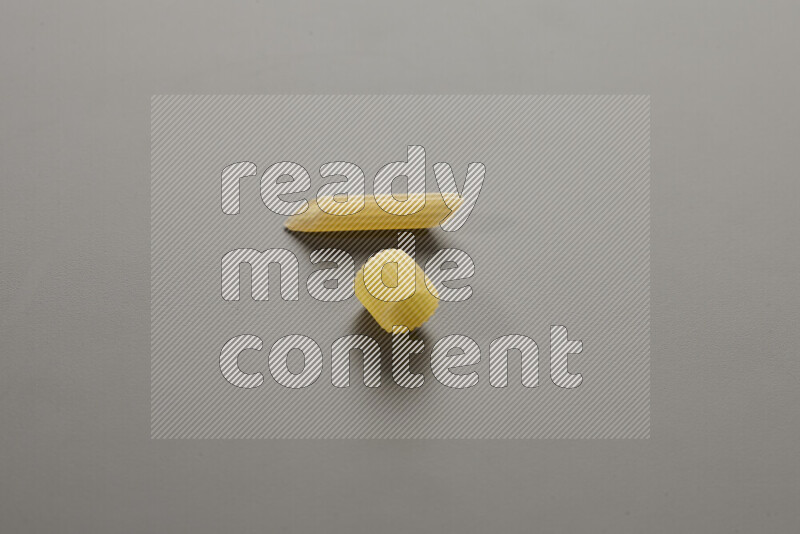 Big rings pasta with other types of pasta on grey background