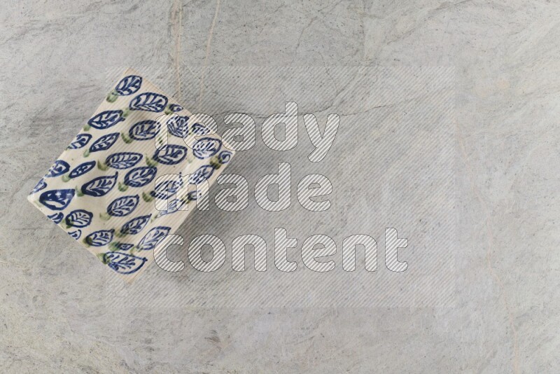 A decorative pottery plate on grey marble background