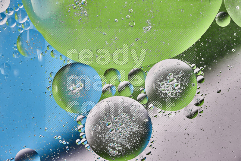 Close-ups of abstract oil bubbles on water surface in shades of white, green and blue