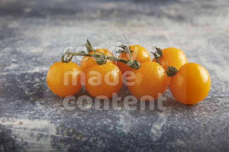 yellow cherry tomato vein on a textured rusty blue background 45 degree